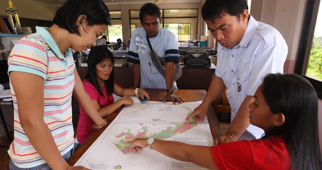 Local officials discuss the hazard map prepared by GGGI through the Ecotown Project in the Philippines.  The final report is available here (http://gggi.org/wp-content/uploads/2014/04/Eco_Town_Framework.pdf) Image Credit: Global Green Growth Institute (GGGI)