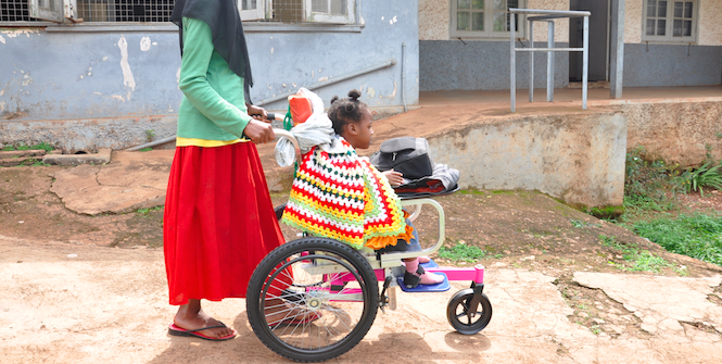 Afiya is pushed by her mother is Sarah in Uganda, in one the donated Wheelchairs.Photo Credit: World Vision Uganda (Simon Peter Esaku/World Vision Uganda) Copyrighted.