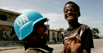 A Bolivian UN peacekeeper playfully picks up a Haitian boy at a checkpoint in Cité Soleil. Photo Credit: Flickr (United Nations Photo) Creative Commons