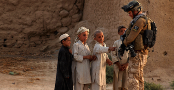 Australian press photographer, Gary Ramage shows his equipment to local Afghan children while on patrol in Dand District with Royal Air Force II Squadron troops, June 26, 2010, Dand District, Kandahar, Afghanistan. Photo source: Kenny Holston (Flickr). Creative Commons.