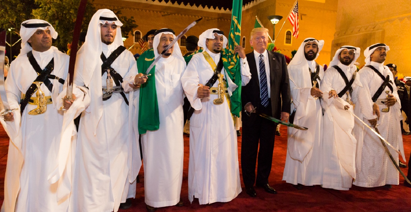 President Donald Trump poses for photos with ceremonial swordsmen on his arrival in Saudi Arabia.