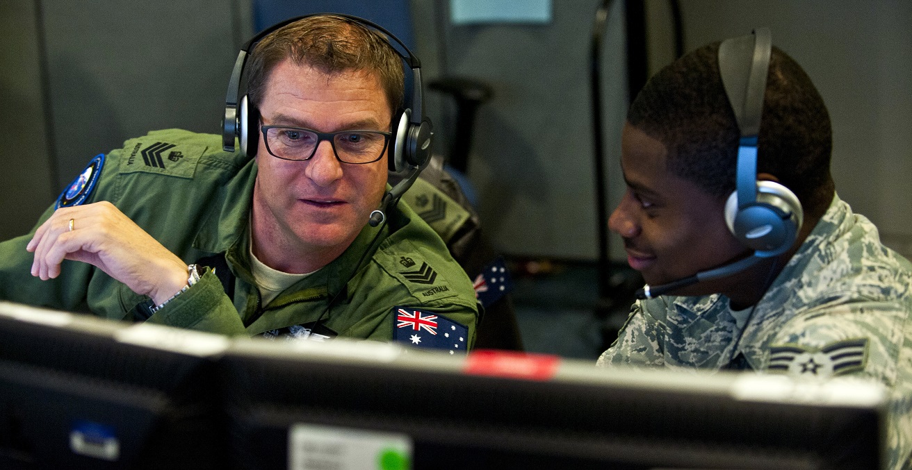 Royal Australian Air Force Flight Sgt. Sean Bedford (left), Australian Space Operations Centre space duty technician, New Norcia, Australia, ., and U.S. Air Force Senior Airman Frederick Riggans-Huguley, 603rd Air and Space Operations Center space duty technician, Ramstein Air Base, Germany, analyze air missile defense systems inside the Combined Air and Space Operations Center-Nellis during Red Flag 14-1 Feb. 5, 2014, at Nellis Air Force Base, Nev. Space duty technicians direct air missile ballistic warnings and provide communication to combat search and rescue teams. 