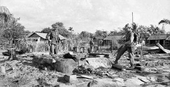 Australian troops examine the ashes and rubble in Long Dien after the Tet Offensive in February 1968. © Commonwealth of Australia (Department of Veterans’ Affairs)