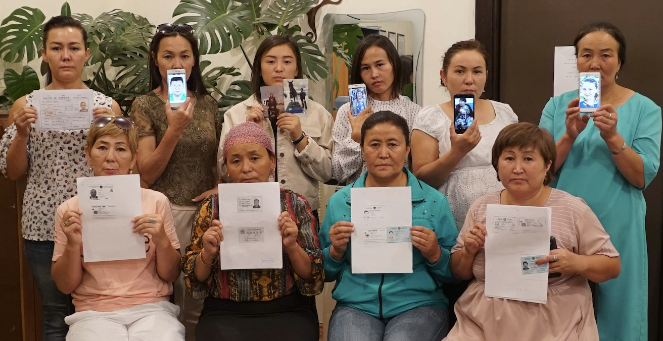 Uyghur women hold up pictures of their detained relatives. Source: Amnesty International