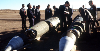 Soviet inspectors and their American escorts stand among several dismantled Pershing II missiles as they view the destruction of other missile components. The missiles are being destroyed in accordance with the Intermediate-Range Nuclear Forces (INF) Treaty. source: Wikimedia Commons