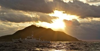 A Coast Guard patrol vessel passes by Uotsuri, the largest island in the Senkaku/Diaoyu chain. Now uninhabited, it used to be home to 248 Japanese, in a community of 99 houses in the late 1890s. They were mostly employed working in a Bonito flake factory on the island. Photo by Al Jazeera English. Source: https://bit.ly/2Ldgfbh