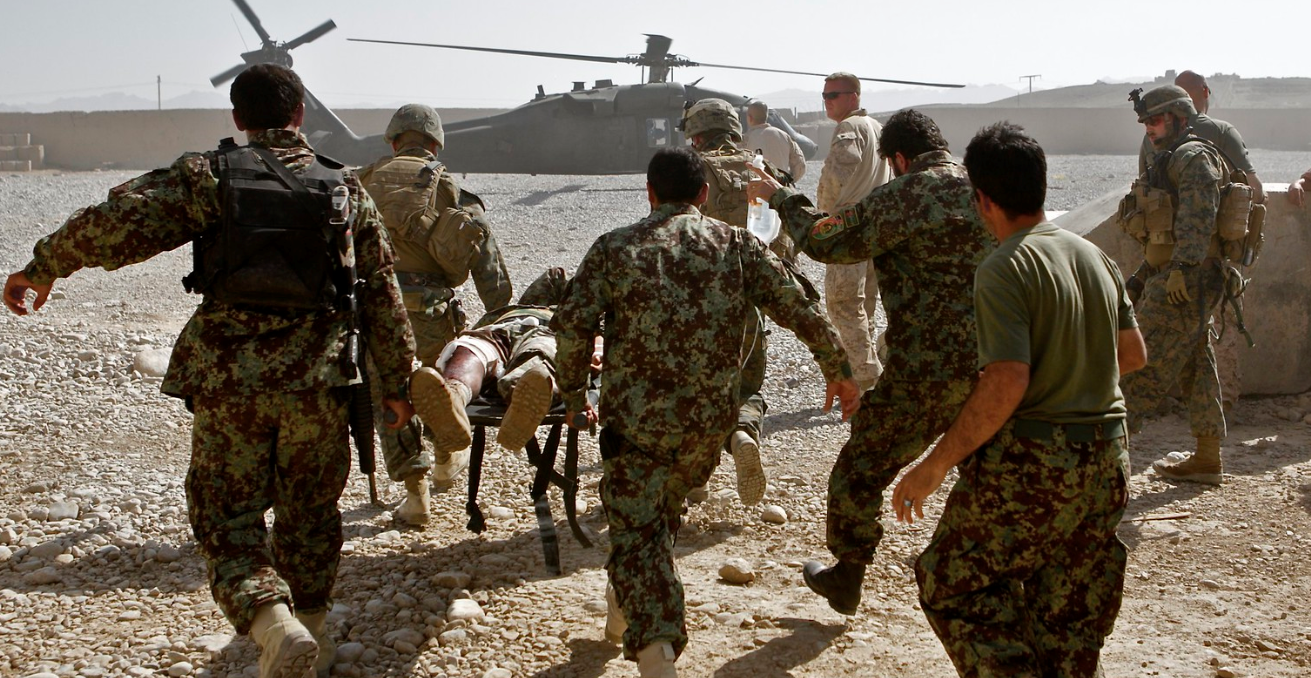 Shot in the leg during a patrol, medics carry an Afghan soldier to an awaiting US helicopter. Source: Al Jazeera English https://bit.ly/3arJd1i