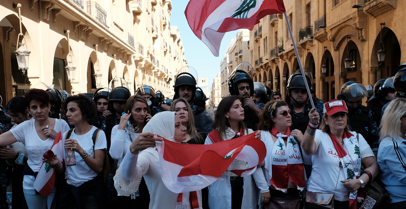 Women protesters forming a line between riot police and protesters in Riad el Solh, Beirut. Source: Nadim Kobeissi https://bit.ly/3bLK9Pg