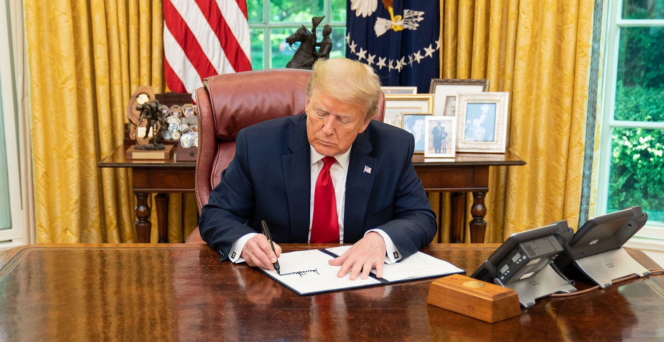 Donald Trump signs an executive order in the Oval Office. Source: Shealah Craighead https://bit.ly/37M9uri
