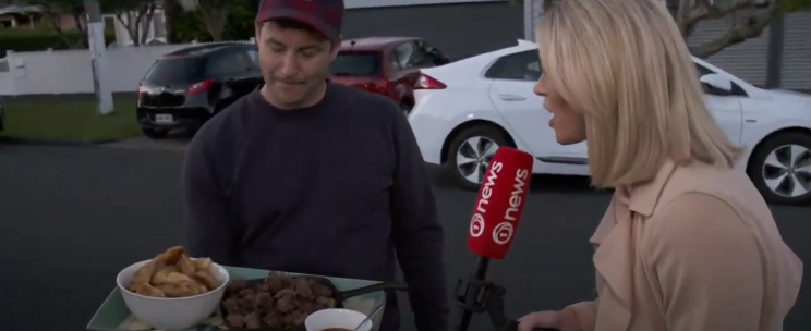 Prime Minister Jacinda Ardern's partner Clarke Gayford offers fried fish and venison bites to journalists waiting outside Ardern's suburban Auckland home. TVNZ.