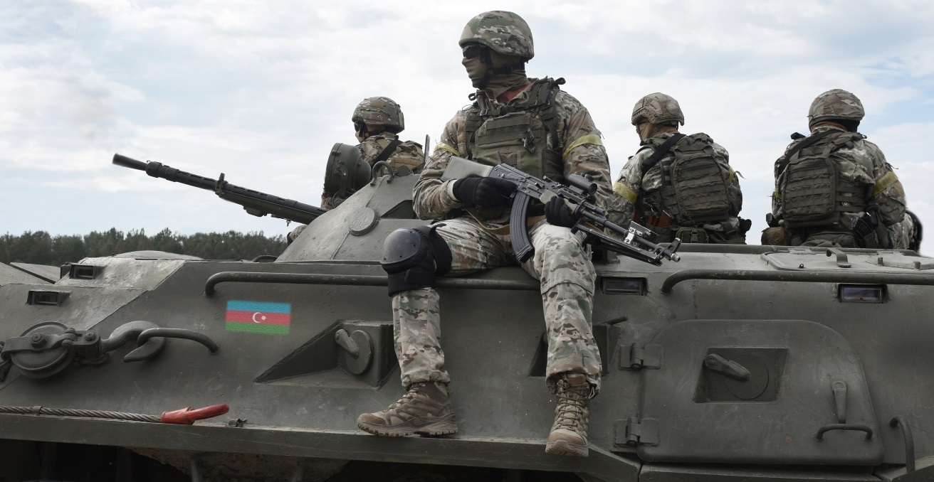 Flag of Azerbaijan on an armored personnel carrier and soldiers with machine guns. Source: Shutterstock.