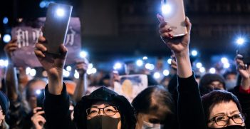 Protestors shine their phone torches toward detained protestors at a solidarity rally for those imprisoned at the Lai Chi Kok Correctional Centre, New Kowloon, Hong Kong. Source: Sandra Sanders/Shutterstock.