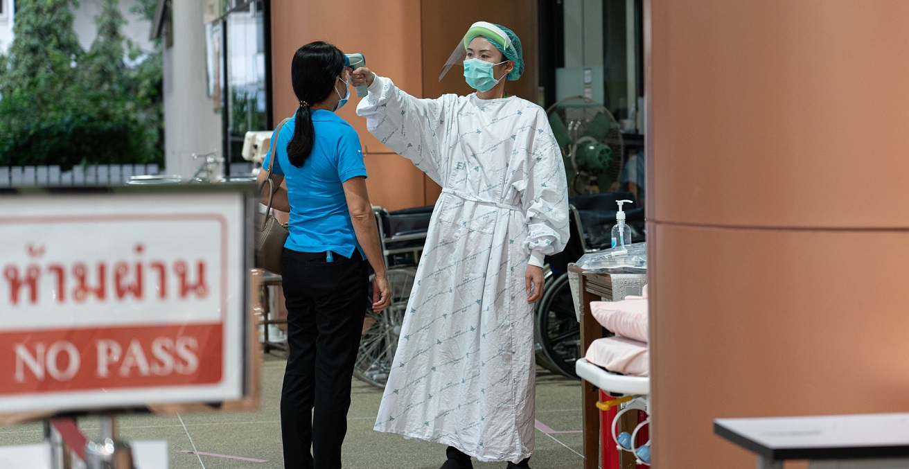 A healthcare worker takes a temperature at Thailand Bamrasnaradura Infectious Disease Institute, Ministry of Public Health. Source: UN Women/Pathumporn Thongking https://bit.ly/3CkHzNL