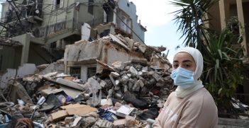 A woman in front of a destroyed house, Karantina, Beirut. Source: Dar Al Mussawir https://bit.ly/3jBweRd