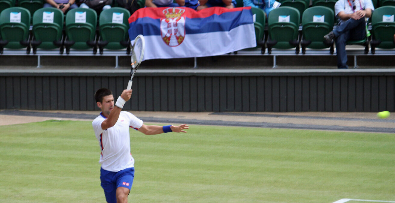 Novak Djokovic holding a Serbian flag, 2012. Source: Simon Williams https://bit.ly/33tFy5t 