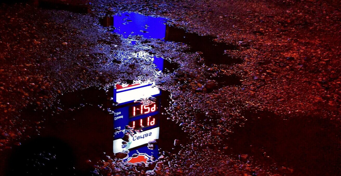 A petrol sign viewed from a muddy puddle in Ruskington, UK. 
Source: Flickr, https://bit.ly/3wtRErd, Kevin Doncaster. 