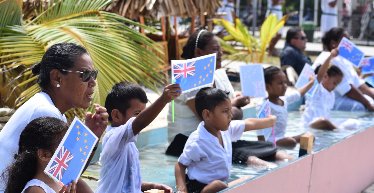 Tuvaluan children sitting in water to demonstrate the impact of climate change, to welcome PIF leaders in 2019. Source: Charles Kadamana. 