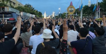 English: Protesters displaying three-finger salute in front of Democracy Monument at August 16 protest. Source: Milktea2020/https://bit.ly/45LbihN