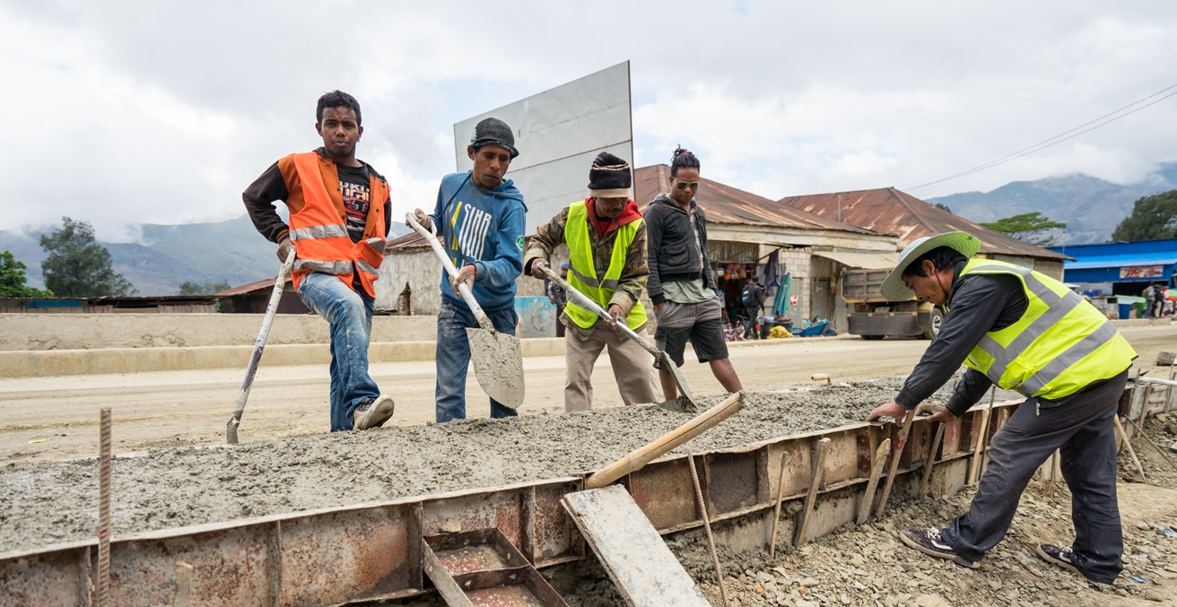Maubisse / Timor Leste - July 25, 2018: Timorese man holding shovel while working building road with Chinese company. Source: The Road Provides / https://t.ly/jjd9c