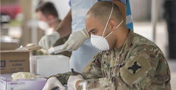 Louisiana Army National Guard Staff Sgt. Jonathan McClellan processes nasal swabs from patients during a drive-through community based COVID-19 testing site located at Louis Armstrong Park, New Orleans, La., March 20, 2020. Source: U.S. Air National Guard photo by Senior Master Sgt. Dan Farrell / https://t.ly/p237s